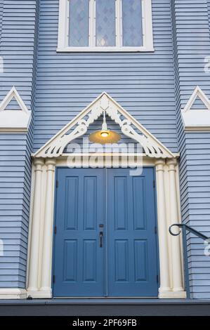 Antique wooden door in to an old wooden church. Blue entrance door. Wooden Gothic Revival style church. North Vancouver, Canada. Nobody, street photo Stock Photo