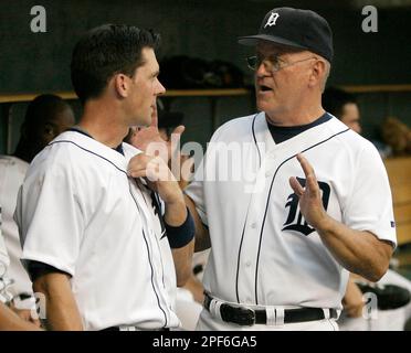 Detroit Tigers pitching coach Bob Cluck, left, reaches out to