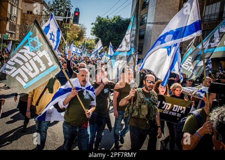 Bnei Brak, Israel. 16th Mar, 2023. Members of the Brothers in Arm reserve soldiers movement hold flags during a protest against the Judicial reform in the Ultra orthodox city of Beni Brak east of Tel Aviv. Israeli protesters held demonstrations against a contentious government plan to overhaul the judiciary, pushing back against Prime Minister Benjamin Netanyahu after he rejected a compromise proposal that was meant to defuse the crisis. (Photo by Eyal Warshavsky/SOPA Images/Sipa USA) Credit: Sipa USA/Alamy Live News Stock Photo