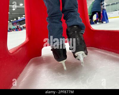 Beginner ice skater using a plastic walker for assistance. Stock Photo