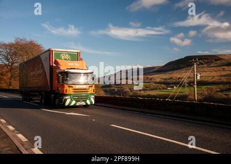 Scania truck pulling a curtainsider trailer driving along the A628 Woodhead Pass in Yorkshire on a sunny Winter afternoon Stock Photo