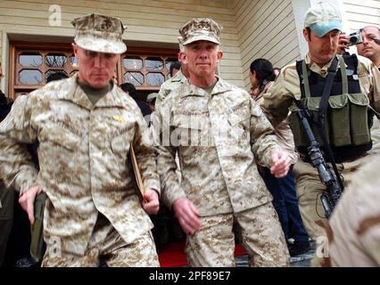 U.S. Marine Corps Maj. Gen. Henry P. Osman, center, is escorted by his unidentified bodyguards after news conference in Salahuddin, Iraq which is controlled by Kurdistan Democratic Party KDP, Monday, March. 24, 2003. Osman, said U.S. forces have arrived in northern in Iraq and he will oversee coordination of humanitarian and military operations in the Kurdistan region of Iraq. (AP Photo/Hasan Sarbakhshian)