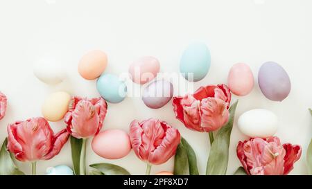 Border of pink parrot tulips and easter eggs on a white background with copy space Stock Photo