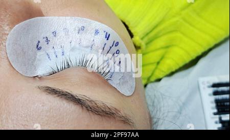 close up of eye with eyelash extension macro view,beauty salon treatment.lash scheme on patch Stock Photo