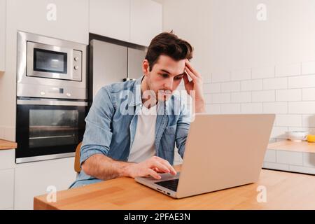 Caucasian man freelancer entrepreneur overworked with burnout headache tired from stress having problems with the laptop computer, frustrated about his job sitting at home. High quality photo Stock Photo