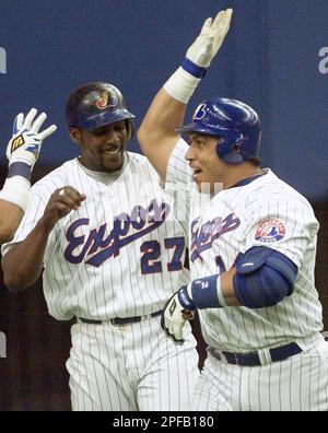 Montreal Expos' Vladimir Guerrero, right, swings for a homerun to  left-center in the sixth inning of the second game of a day-night  doubleheader against Cincinnati Reds at the Hiram Bithorn Stadium in