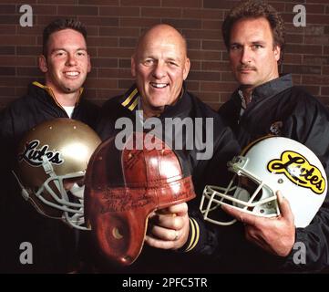 https://l450v.alamy.com/450v/2pfc5tr/pacific-lutheran-head-football-coach-frosty-westering-center-holds-a-leather-football-helmet-like-the-one-he-wore-as-a-player-in-this-nov-8-1999-photo-on-the-school-campus-in-parkland-wash-at-left-is-his-grandson-chad-johnson-current-lute-quarterback-at-right-is-scott-westering-frostys-son-and-offensive-coordinator-the-leather-helmet-is-covered-with-the-autographs-of-famous-football-coaches-ap-photothe-news-tribune-bruce-kellman-2pfc5tr.jpg