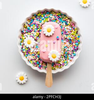 A homemade cakesicle decorated with edible bees in a bowl full of sprinkles  Stock Photo - Alamy