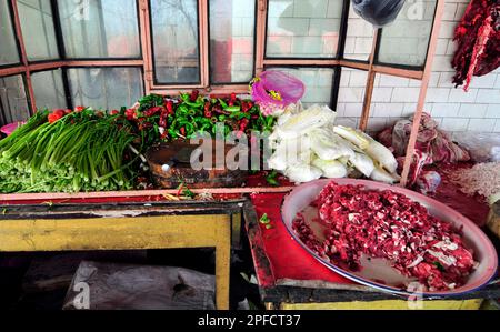 Fresh lamb meat, chillies and veggies in a kitchent of a small roadside restaurant at a market in the outskirts of Kashgar, Xinjiang, China. Stock Photo