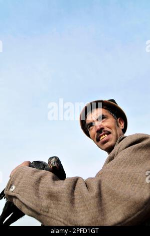 Portrait of an Uyghur man with his chicken taken at a weekly livestock market in the outskirts of Kashgar, Xinjiang, China. Stock Photo