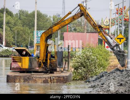 A floating dredger is dredging the bottom of the pond, Thailand Stock Photo