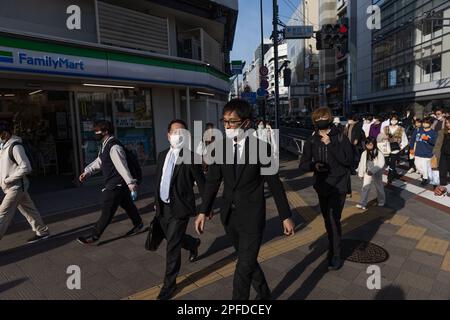 Businessmen walk towards Shinjuku station in Tokyo. Japan eased COVID-19 guidelines for mask-wearing on March 13, 2023. (Photo by Stanislav Kogiku / SOPA Images/Sipa USA) Stock Photo