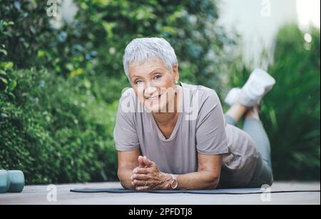 Little effort today for a longer tomorrow. Portrait of an older woman relaxing during her workout on the floor outside. Stock Photo