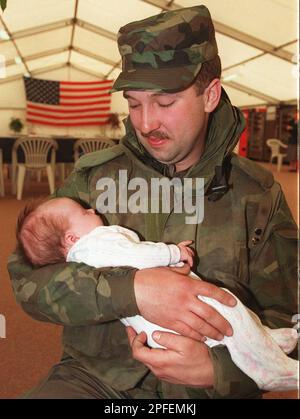 U.S. Army Spec. Russel Mills of Suffield, Conn., holds his baby Sydney, who was born one month and three days ago, at Rhein-Main Airport in Frankfurt, Germany, on Monday, April 15, 1996. Mills is seeing his baby for the first time in person since he was deployed with U. S. troops to Bosnia. About 135 U.S. soldiers arrived for two week break after they spent between four and five months in Bosnia. (AP Photo/Heribert Proepper)