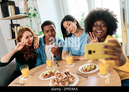 Happy multiethnic friends talking a selfie at home Stock Photo