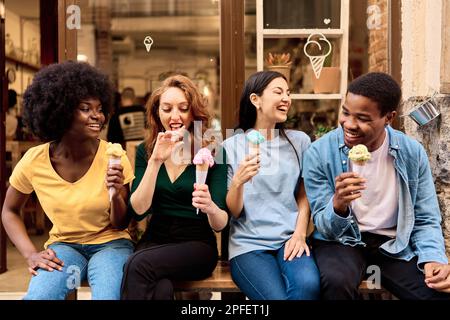 Friends having fun while eating an ice cream in the city street Stock Photo