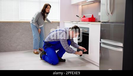 Repairman Technician Man Repairing Household Oven Appliance Stock Photo