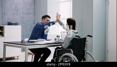 Businesswoman With Disability Giving High Five To Her Partner In Office Stock Photo