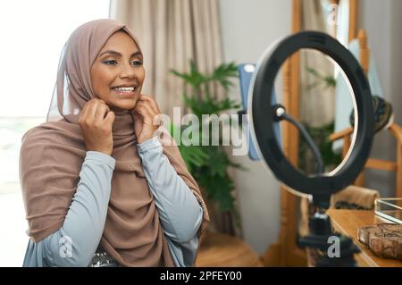 This is my side hustle. a young muslim female busy recording her for her vlog. Stock Photo
