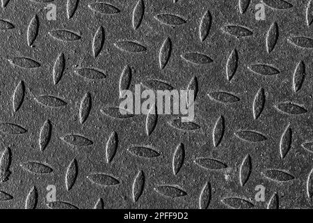 Old grungy metal plate texture with diamond plate pattern. Background black and white photo Stock Photo