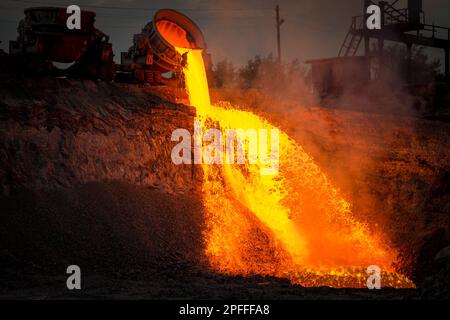 Discharge of metallurgical slag from blast furnaces. Beautiful stream of hot slag Stock Photo