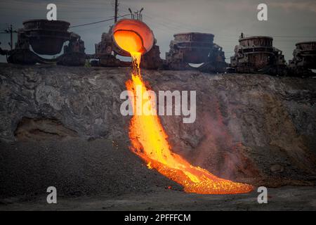 Discharge of metallurgical slag from blast furnaces. Beautiful stream of hot slag Stock Photo