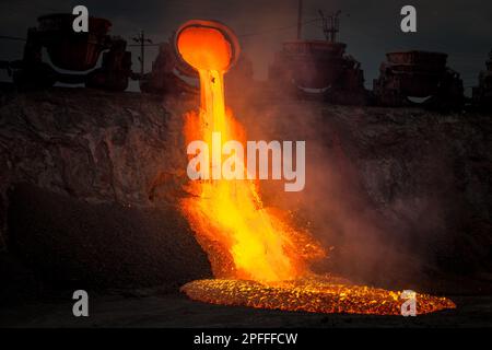 Discharge of metallurgical slag from blast furnaces. Beautiful stream of hot slag Stock Photo