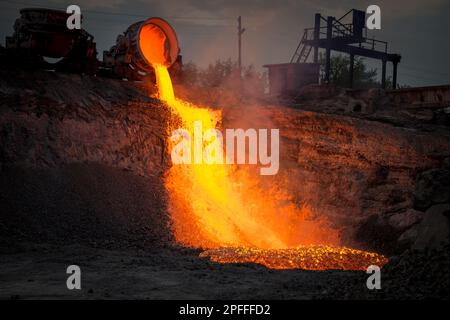 Discharge of metallurgical slag from blast furnaces. Beautiful stream of hot slag Stock Photo