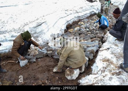 Rudarprayag, Uttarakhand, India, May 18 2014, Laborer reopening Kedarnath trek locked by snowfall. Kedarnath is ancient and magnificent temple is loca Stock Photo