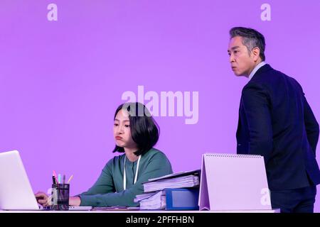 relationship and conflict between younger and older workers concept, Korean Asian young woman and manager level older man Stock Photo