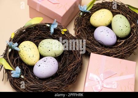 Gifts for Easter, Easter sale. Eggs in nests and gift boxes on a beige background Stock Photo