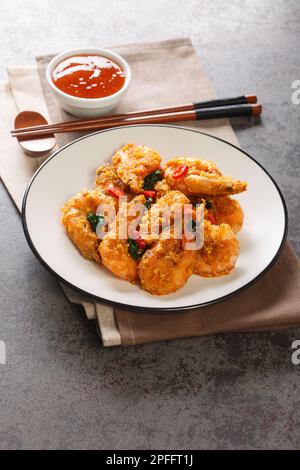 Salted Egg Prawns are rich, creamy and full of umami flavour close-up in a plate on the table. Vertical Stock Photo