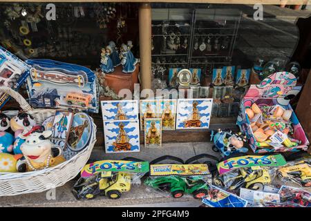 Religious souvenirs in a shop window of  'Our Lady of Guadalupe' among toys in a souvenir shop. Guadalupe, Caceres province, Extremadura, Spain. Stock Photo