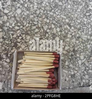 Close up of open single cardboard match box on granite stone background, Box filled with tiny match sticks Stock Photo
