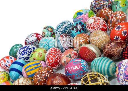 Lots of colorful Easter eggs laid out randomly on a solid white background. Stock Photo