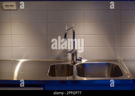 Modern interior of apartment. Luxury grey kitchen set. Huge sink. Built-in elements. Stock Photo
