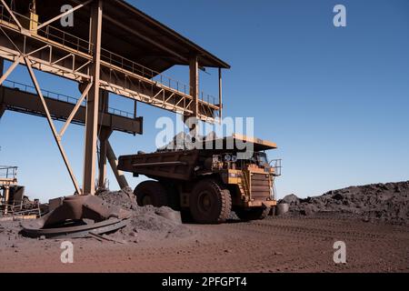 Trucks loading iron ore at the SNIM open-pit iron ore mine. Zouerat, Mauritania. Stock Photo