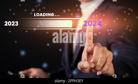 Businessman pointing or touching 2024 to 2023. loading bar for counting down from 2023 to 2024. starting a business and success Stock Photo