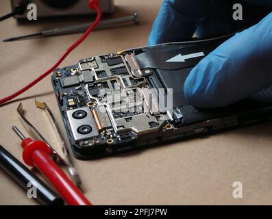 Mobil phone parts and tools for fixing. Smartphone circuit board. Technician repair or cleaning smartphone in technical lab. Stock Photo
