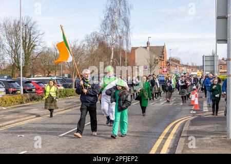 2023 St Patrick’s Day Parade in Orford Lane Warrington. The Irish Flag leads the procession Stock Photo