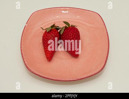 Fresh organic raw strawberries on ceramic plate isolated on white Stock Photo