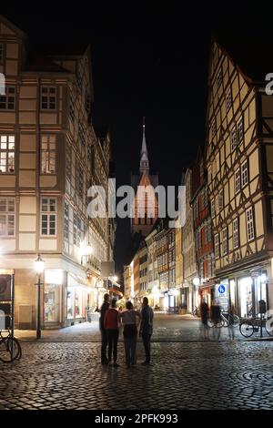 Hannover, Germany - September 9, 2016: Tourists exploring the old town district at night. Pedestrianized Kramerstrasse (grocer street) with its Stock Photo