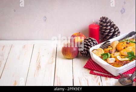 Roasted chicken. Christmas food background. Celebration white wooden table with roasted chicken, apples, decorated with candles, cones, vintage Stock Photo