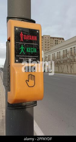Traffic light pedestrian button in the form of a yellow panel with luminous navigation Stock Photo