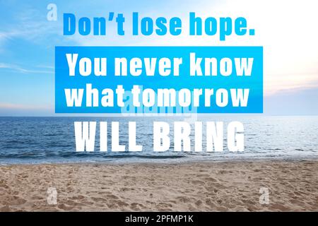 Don't Lose Hope You Never Know What Tomorrow Will Bring. Inspirational quote saying about patience, belief in yourself and next day. Text against sand Stock Photo