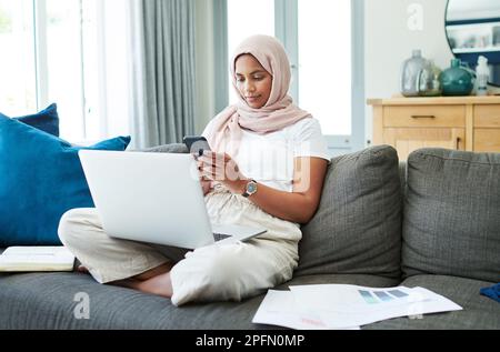 Whats the interest rate at the moment. an attractive young woman sitting on her sofa at home and calculating her finances with technology. Stock Photo