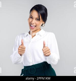 Whatever youre passionate about, thats your purpose. Studio shot of a confident young businesswoman giving a thumbs up against a grey background. Stock Photo