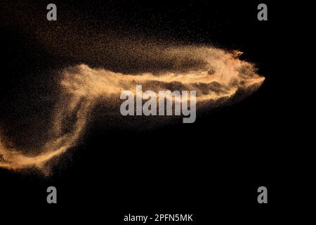 Brown colored sand splash.Dry river sand explosion isolated on black background. Stock Photo