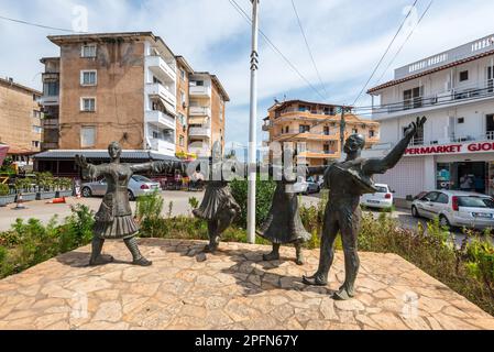 Ksamil, Albania - September 16, 2021: Monument with dancers in national Albanian clothes in the city center of Ksamil village center street. Stock Photo