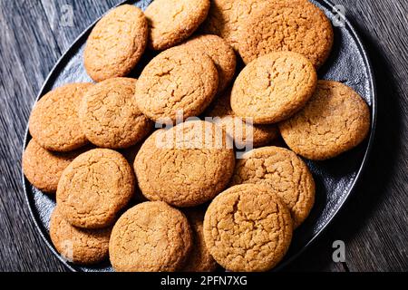 soft ginger cookies on black plate on dark wood table, close-up Stock Photo